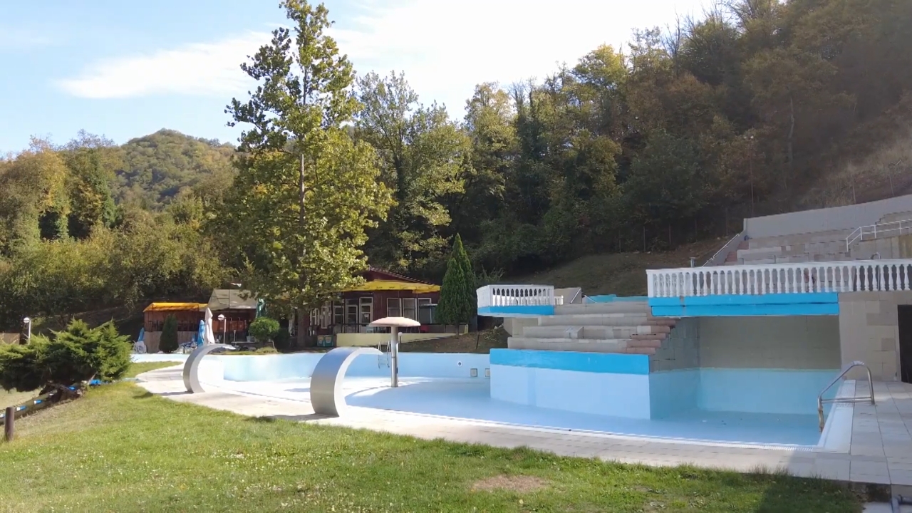 Otvoreni bazen u Sijarinskoj Banji okružen zelenilom i šumom